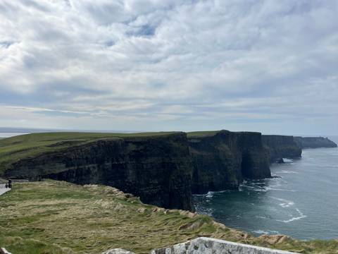 Cliffs overlooking the ocean under a cloudy sky.