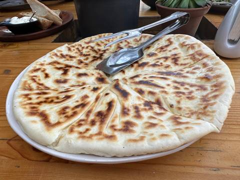       A freshly baked flatbread served on a plate.
  