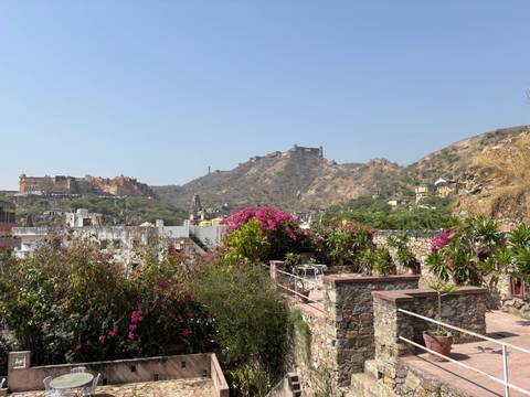       View of a historic fort and hills with bougainvillea.
  