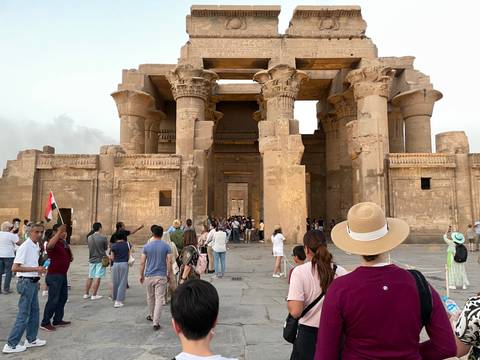 Visitors at the entrance of an Egyptian temple complex.