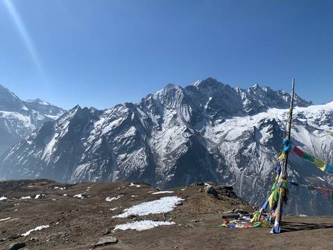 Snow-capped mountain range with prayer flags.