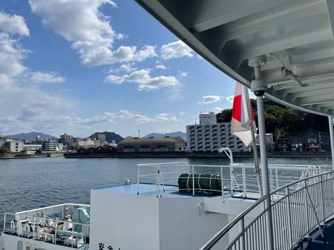 View of a city from a water vessel with a Japanese flag