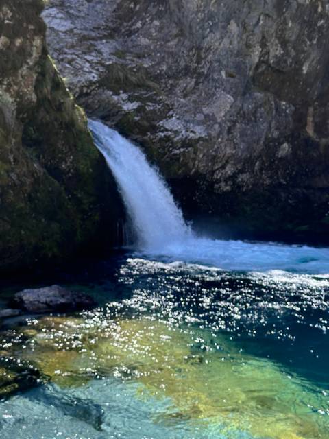       Waterfall cascading into a pool.
  