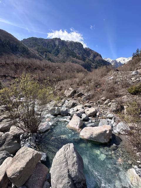       Mountain stream flowing through a rocky landscape.
  