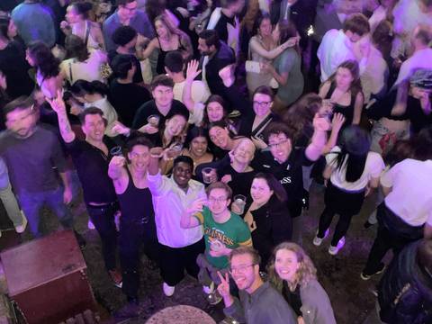 People gathering at a night event with drinks.