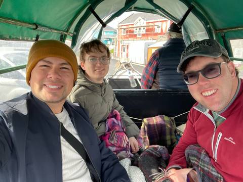 Friends riding in a horse-drawn carriage.