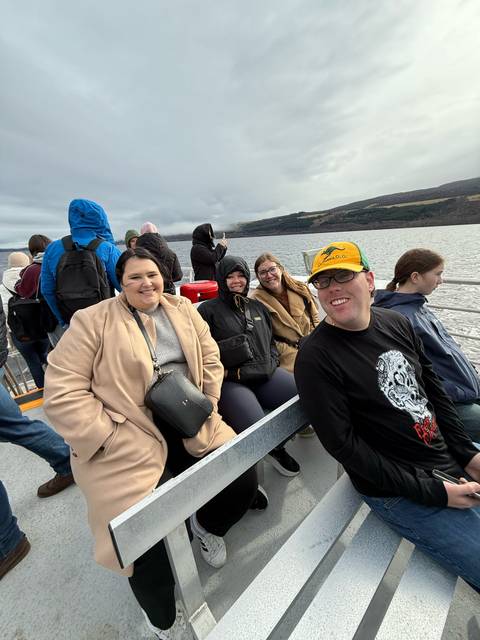 Group of people on a boat with a large lake in the background.