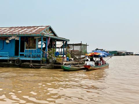 Boats docked near floating wooden houses.