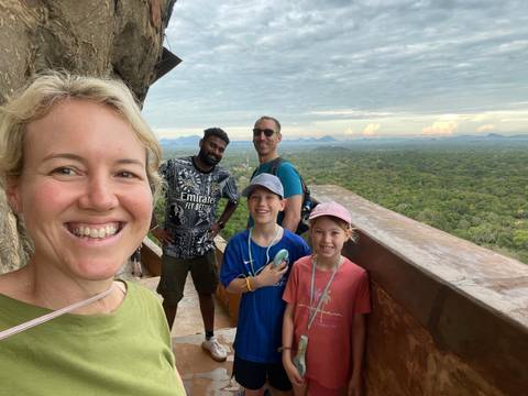 Family posing on a balcony with a landscape view.
