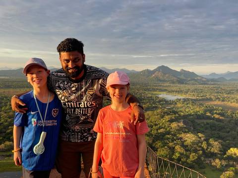       Children with an adult posing with a scenic view.
  