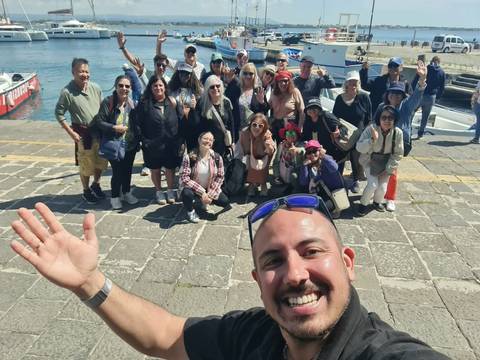 Group of tourists taking a selfie by the waterfront.