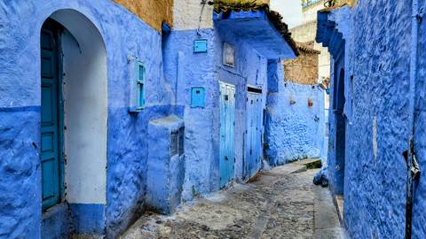 Narrow alleyway with blue painted walls characteristic of Chefchaouen.