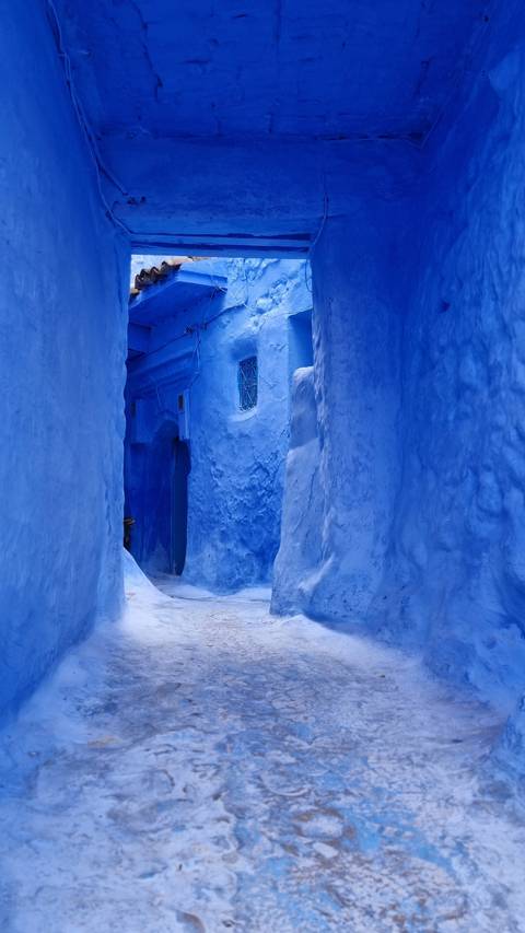 Blue-painted narrow passageway typical of Chefchaouen.