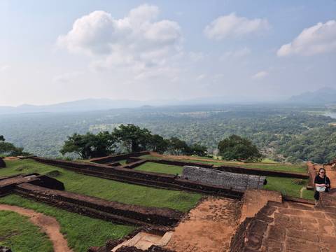      View from a high vantage point of Sigiriya ruins overlooking a lush landscape.
  
