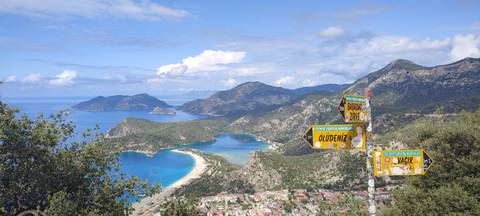 Panoramic view of a bay with mountains and turquoise water.