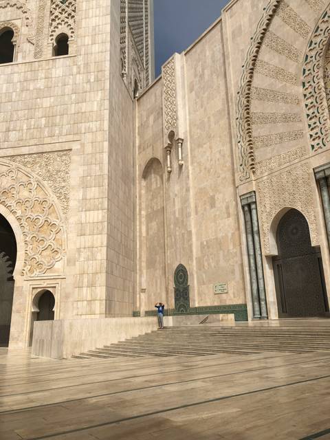Person standing near architectural building with intricate designs.
