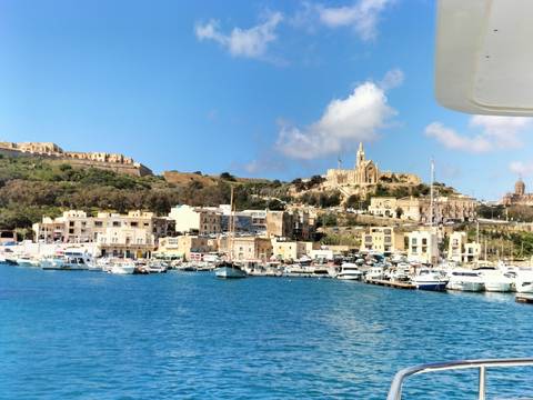 Harbor with boats and a historic building in the background.