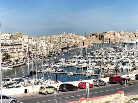 Marina filled with yachts and a cityscape in the background.