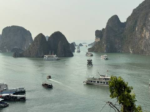 Boats in a scenic bay surrounded by limestone karsts.