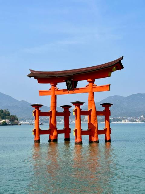 Traditional Japanese torii gate with mountains in the background.