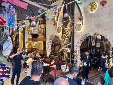 Busy indoor market with ornate decorations and people.