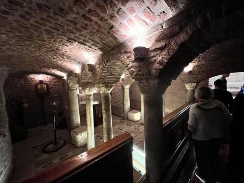 Ancient catacombs with intricately carved pillars.