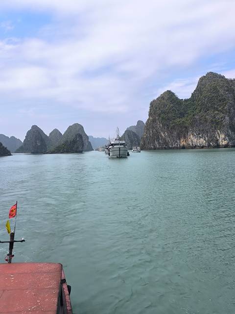 Boats navigating through the limestone karsts of Halong Bay.