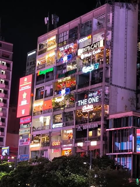 Café buildings with bright neon lights illuminating the night.