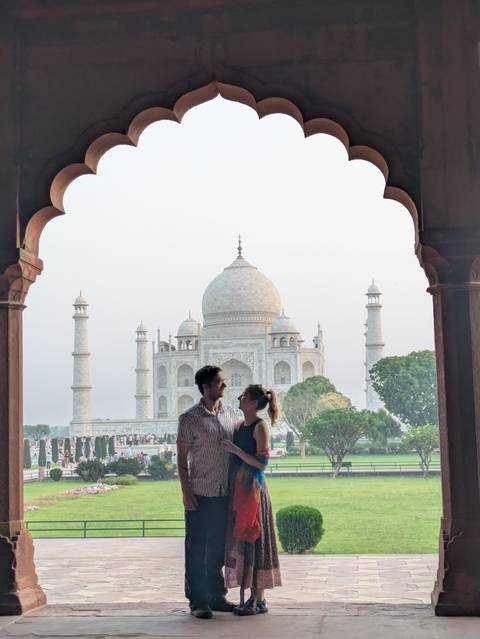Couple posing with the Taj Mahal in the background.