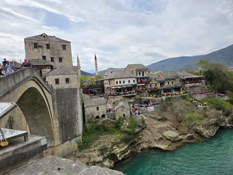 Historic bridge and traditional buildings with a scenic river.