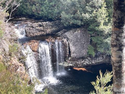 Waterfall cascading over rocks into a pool.