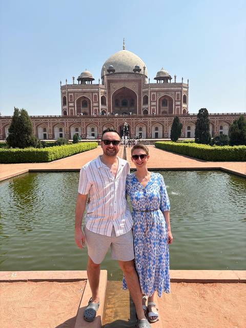 Couple posing in front of a historic building.