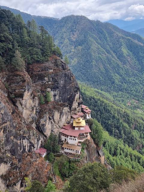       View from a high vantage point of Taktshang Monastery on a cliffside.
  