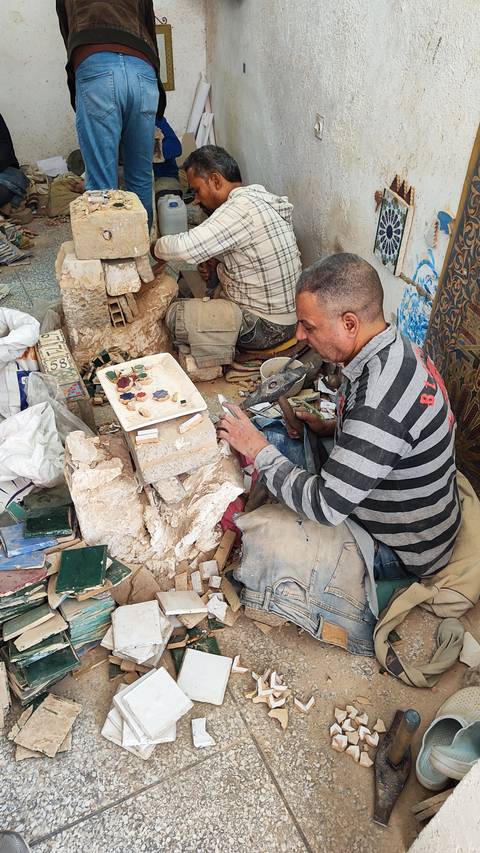      Man working on crafts and stone pieces.
  