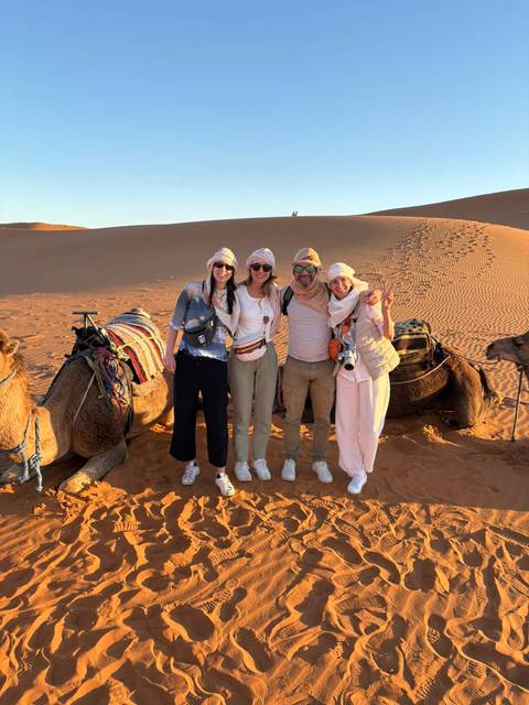 Tourists with camels in the desert.