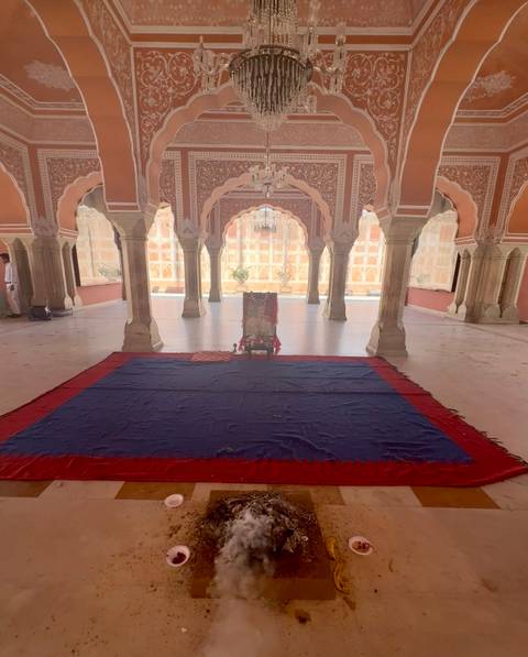 Ornately decorated room with arches and a carpet.