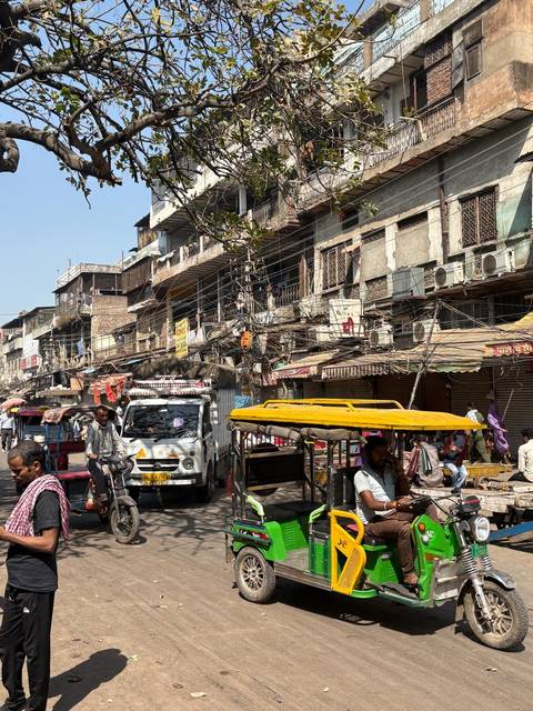 Street scene in an Indian city with vehicles and crowded electrical wires.