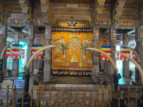 Ornate interior of a temple with colorful decorations and tusks.