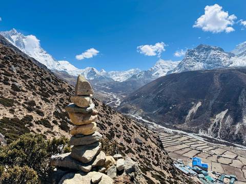 Cairn in front of a vast mountainous valley.