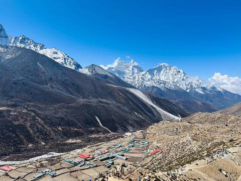 Mountains and a village in a valley, covered in light snow.