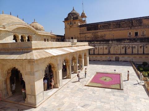      Tourists exploring a historic fort with detailed architecture.
  