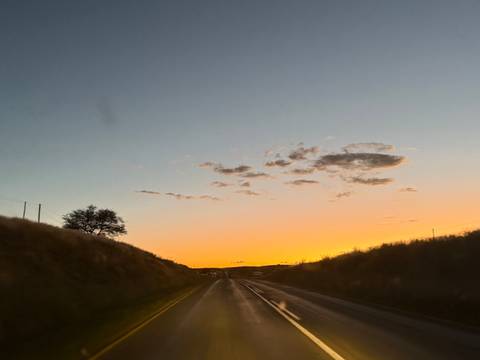       Sunset view over a road with dramatic sky colors.
  