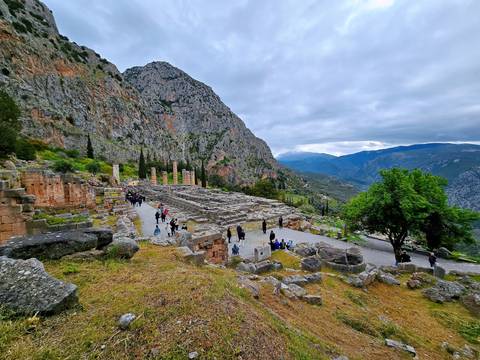 Ruins of an ancient site with mountains in the background.