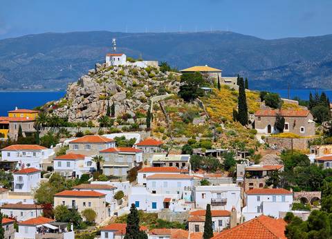       Hillside town with traditional architecture and sea in the background.
  