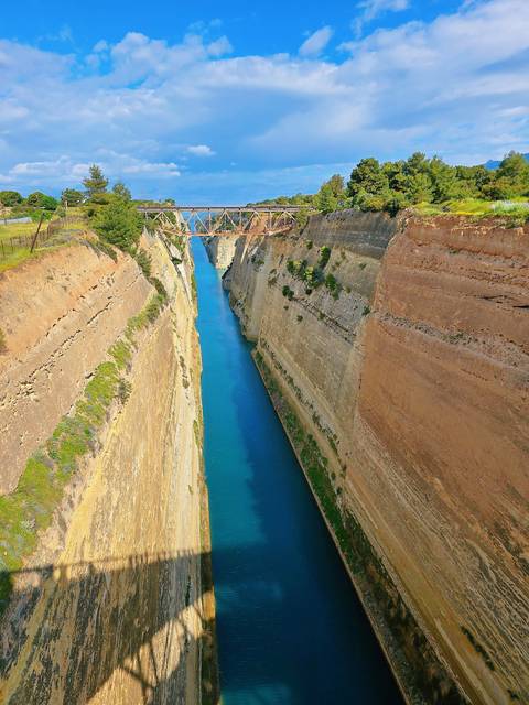       A canal with steep rock walls and a bridge.
  