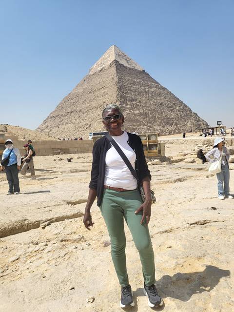       Person standing in front of a pyramid in Giza.
  