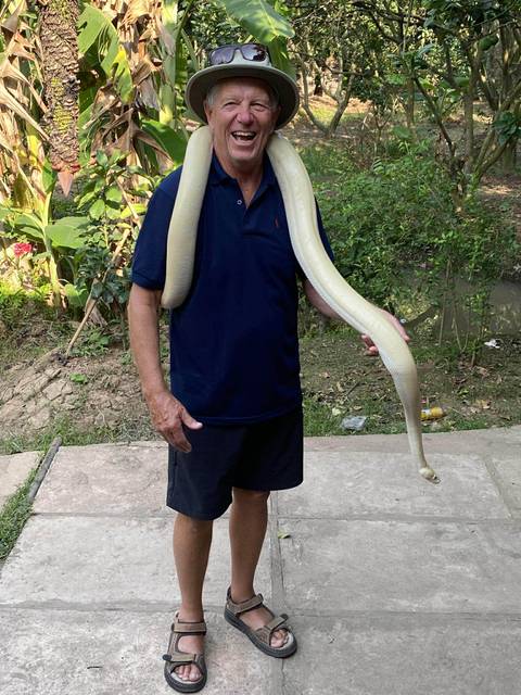       Person with a large snake draped around their shoulders
  