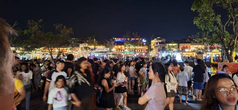       Crowded market street with colorful lights at night
  