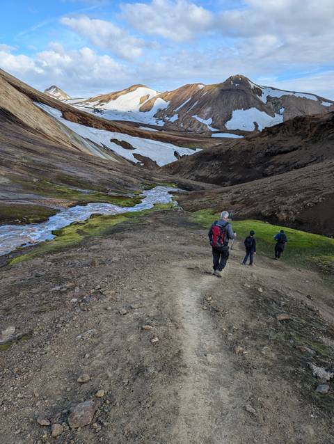Hikers exploring a colorful volcanic landscape.