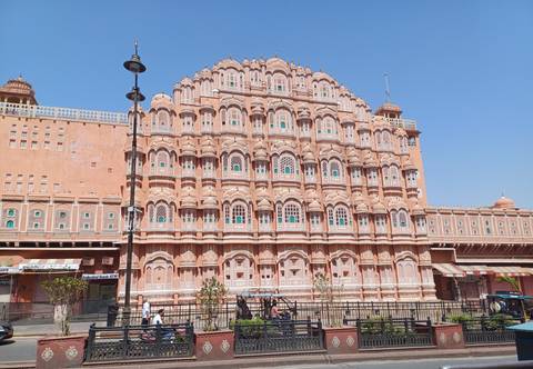Ornate facade of a pink building with multiple windows.